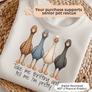以下が含まれることがあります： さまざまな模様と色で描かれた4羽のガチョウの気まぐれなイラストが特徴の白いスウェットシャツ。「Take me thrifting and tell me I'm pretty」の文字が下にあります。画像には「Your purchase supports senior pet rescue」というテキストも含まれています。