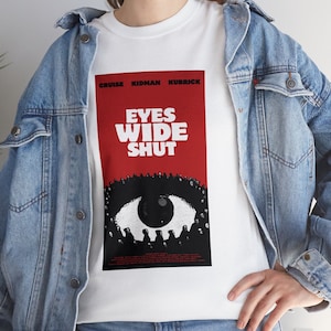 May include: White t-shirt featuring a red and black graphic of an eye with the text "Eyes Wide Shut" and the names "Cruise, Kidman, Kubrick" above the eye.