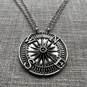 May include: Two silver necklaces with a matching compass pendant that reads "We are never" on one side and "separated" on the other side.