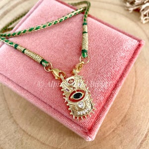 Colar com pingente de olho grego banhado a ouro e zircônia cúbica, com cordão indiano Dori.