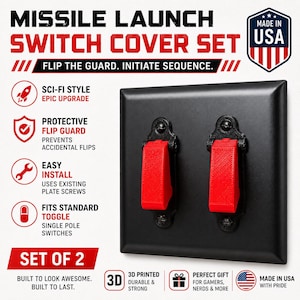 Könnte beinhalten: Eine schwarze Doppel-Lichtschalterabdeckung mit zwei roten Schutzklappen. Der Text lautet MISSILE LAUNCH SWITCH COVER SET, FLIP THE GUARD. INITIATE SEQUENCE, SCI-FI STYLE, PROTECTIVE FLIP GUARD, EASY INSTALL, FITS STANDARD TOGGLE, SET OF 2.