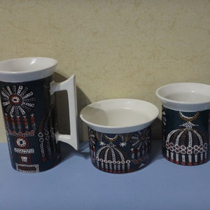 Peut inclure: Un ensemble de trois tasses en céramique avec un motif géométrique noir et blanc. Les tasses présentent un motif répétitif de cercles, de lignes et de points. Les tasses sont de différentes tailles, la plus grande étant un pichet.