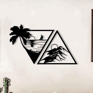 Puede incluir: Arte de pared de metal negro con dos triángulos, uno que representa una palmera en una playa con un velero y el otro que representa una cordillera. El arte se muestra en una pared blanca sobre un sofá marrón con almohadas.