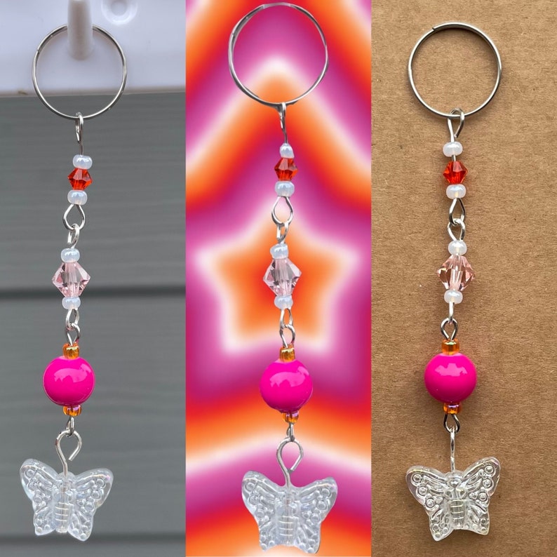 May include: A pink and clear butterfly charm keychain with a silver ring, pink beads, and clear crystal beads.