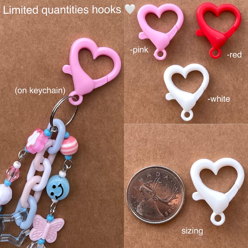 Op de afbeelding: Afbeelding toont hartvormige haken in roze, rood en wit. E&eacute;n haak is bevestigd aan een sleutelhanger met kralen en bedels. Tekst luidt "Limited quantities hooks" en "sizing".