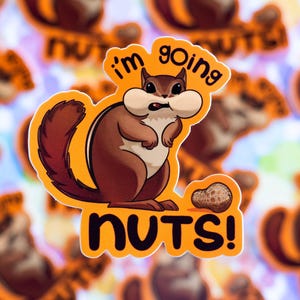 Puede incluir: Una pegatina con una ardilla de dibujos animados con una expresión de sorpresa y las palabras "I'm going nuts!" en naranja y negro. Un cacahuete está al lado de la ardilla. El fondo es un patrón borroso de pegatinas similares.
