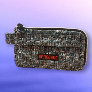 May include: A small, gray and blue zippered pouch with a black strap and the word "RENEGADE" in red embroidered on the front.