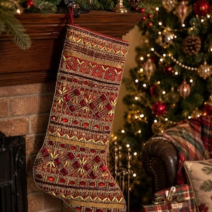 May include: A Christmas stocking featuring intricate beadwork and embroidery in shades of deep red and metallic gold. The surface is adorned with geometric patterns, small seed beads, and larger red faceted jewels arranged in horizontal bands.