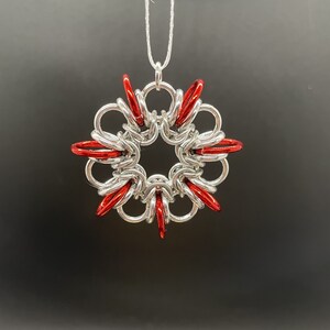 May include: A silver and red snowflake ornament with a chain for hanging.