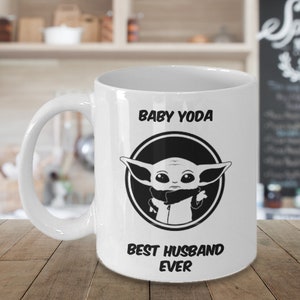Puede incluir: Taza de caf&eacute; de cer&aacute;mica blanca con una imagen en blanco y negro de Baby Yoda en un c&iacute;rculo con el texto "Baby Yoda Best Husband Ever".