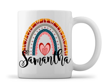 May include: White ceramic mug with a colorful rainbow design and the name Samantha printed in black cursive. The rainbow has a heart in the center.