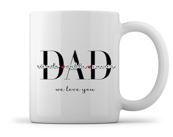 Może przedstawiać: Biały kubek ceramiczny z napisem "DAD" w czarnych, pogrubionych literach. Nazwy "ricardo", "nahla" i "xavier" są napisane kursywą z czerwonym sercem między każdym imieniem. Tekst "we love you" jest napisany pod słowem "DAD".