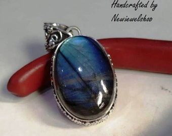 A Shimmering silver handcrafted pendent studded with oval shaped natural Labradorite gemstone for men and women.