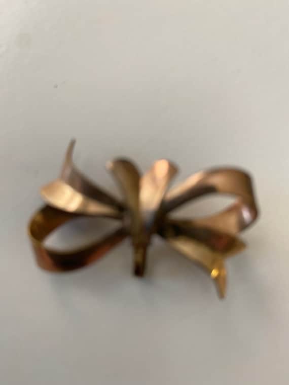 Bow pin designed to hold charm or watch on hidden 