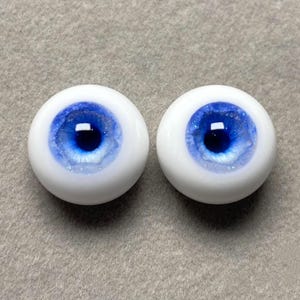May include: Two blue and white doll eyes with a sparkly finish. The irises are a deep blue with a white ring around the pupil.