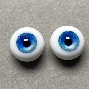 May include: Two blue doll eyes with white sclera and a dark blue iris. The eyes have a sparkly blue glitter effect.