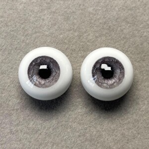 May include: Two gray and white doll eyes with a glitter finish. The irises are a dark gray with a black pupil.