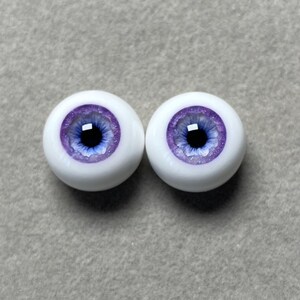 May include: Two purple and white doll eyes with a blue iris and a glitter finish.