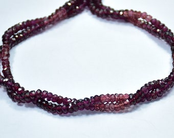May include: A strand of faceted gemstone beads in shades of pink and purple. The beads are strung on a clear thread and are arranged in a loose, flowing pattern.