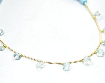 May include: A gold chain necklace with light blue teardrop-shaped gemstone beads.