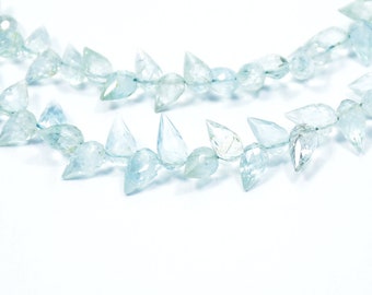 May include: A strand of light blue aquamarine gemstone beads, each bead is faceted and shaped like a teardrop with a pointed tip.