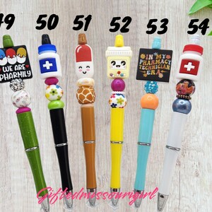 K&ouml;nnte beinhalten: Eine Sammlung von sechs dekorativen Stiften mit einzigartigen Designs. Jeder Stift verf&uuml;gt &uuml;ber einen farbenfrohen Perlenakzent und einen thematischen Aufsatz, darunter eine Apothekenflasche, eine Kaffeetasse und der Text "WE ARE PHARMILY" und "IN MY PHARMACY TECHNICIAN ERA".