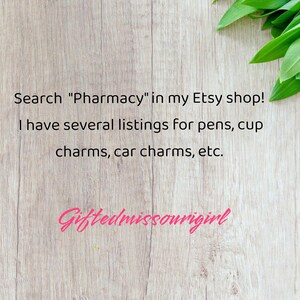 K&ouml;nnte beinhalten: Holzhintergrund mit Text: "Suche 'Apotheke' in meinem Etsy-Shop! Ich habe mehrere Angebote f&uuml;r Stifte, Becheranh&auml;nger, Autoanh&auml;nger usw." Der Shop-Name "Giftedmissourigirl" ist ebenfalls sichtbar.
