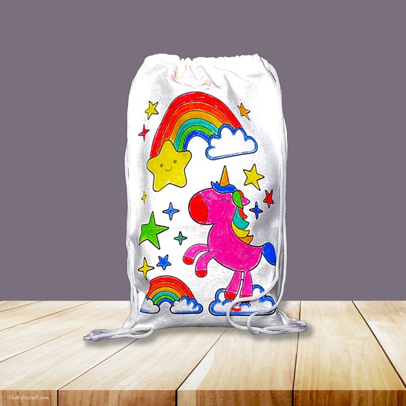 May include: White drawstring bag with a colorful unicorn, rainbow, and stars design. The bag is perfect for carrying small items like toys, books, or snacks.