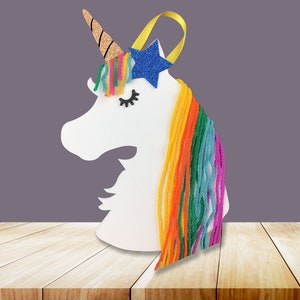 May include: White unicorn head cutout with a blue glitter star and rainbow yarn mane.
