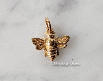 May include: Gold-toned bee charm pendant. The bee is detailed with wings, legs, and a segmented body.