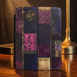 May include: A decorative book cover with a patchwork design. The cover features a mix of dark blue, purple, and gold squares with floral and damask patterns. A small purple rose is visible on the right side of the cover.