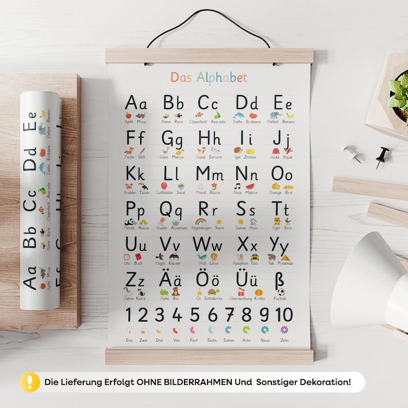 May include: A colorful alphabet chart with the German title "Das Alphabet" and corresponding illustrations for each letter. The chart is displayed on a wooden frame and includes numbers 1-10. A rolled-up matching poster is visible.