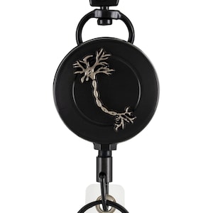 May include: Black retractable badge reel with a silver neuron design on the front. The reel has a black clip and a white plastic badge holder.