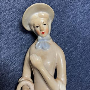 Vintage viktorianische Dame, die eine Blumenkorb-Figürchen hält