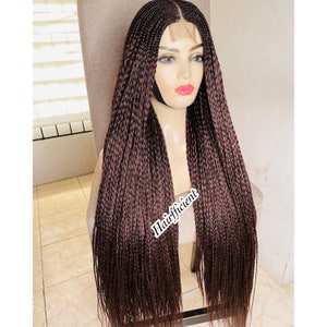 May include: A long, brown braided wig with a lace front. The wig is styled in a straight, sleek style. The wig is on a mannequin head.