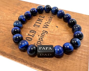May include: Blue tiger's eye beaded bracelet with a black bead engraved with "PAPA DAD".