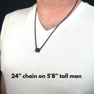 Peut inclure: Un collier en cha&icirc;ne noire de 61 cm avec un petit pendentif en perle noire. La cha&icirc;ne est port&eacute;e par une personne portant un t-shirt blanc. "24" chain on 5'8" tall man"