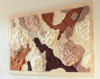 May include: A large rectangular wall hanging featuring a tufted fiber art design in a wooden frame. The composition displays an abstract pattern of organic shapes in shades of cream, white, terracotta, dark brown, and dusty pink with varied textures.