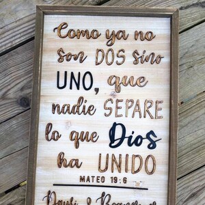 May include: A wooden sign with a brown frame and a white background. The sign has a quote in Spanish that reads "Como ya no son DOS sino UNO, que nadie SEPARE lo que Dios ha UNIDO" with the scripture reference "MATEO 19:6". Below the quote are the names "Daysi & Boanerges" and the date "24-04-21".