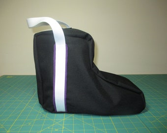 May include: Black boot bag with a white and purple strap. The bag has a handle and is made of a durable fabric.