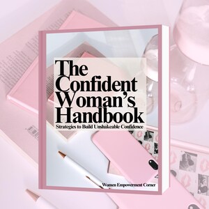 Puede incluir: Imagen de un libro titulado "The Confident Woman's Handbook" con el subtítulo "Strategies to Build Unshakeable Confidence". La imagen también presenta otros libros rosas, una funda de teléfono rosa y un bolígrafo. El texto "Women Empowerment Corner" también es visible.
