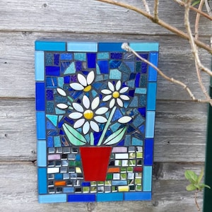 Pretty mosaic daisy. Handmade using tiles, mirror and stained glass. A big piece that will be noticed and reflect sunlight.