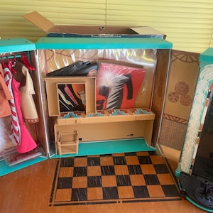 May include: A vintage doll wardrobe playset, open to reveal clothing and accessories. The wardrobe is teal and tan with a checkered floor. Clothing includes a white faux fur stole and dresses.