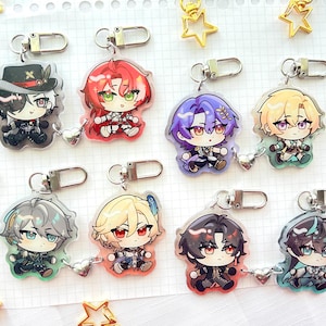 May include: Ten colourful anime character keychains with silver metal rings. Each keychain features a different character with unique hair and clothing styles. The characters are drawn in a cartoon style with large eyes and expressive faces.