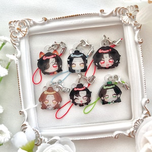 May include: Six anime-style character charms with silver clasps and colorful lanyards. Each charm features a different character with unique hairstyles and facial expressions. The charms are displayed inside a white ornate picture frame.