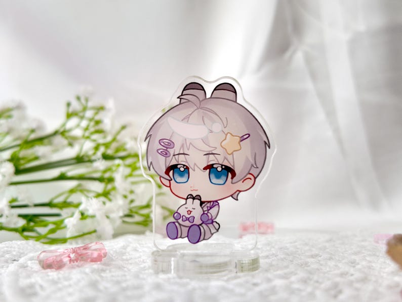 May include: A white and purple anime character with white hair and blue eyes holding a white bunny plush. The character is standing on a clear acrylic stand.