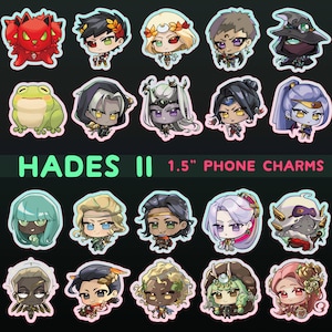 May include: A set of 18 colorful phone charms featuring characters from the video game Hades II. The charms are 1.5 inches in diameter and feature a variety of characters, including a frog, a red creature with horns, and a variety of human characters with different hairstyles and clothing.