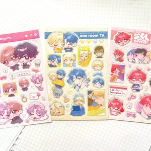 May include: Three rectangular sticker sheets featuring chibi-style anime characters. The left sheet is titled Virtual Strangers, the center sheet is titled one room TA, and the right sheet is titled One Room TA with various character illustrations.