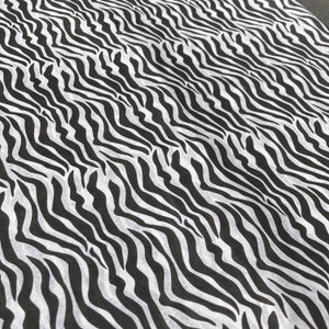 Puede incluir: Tela de estampado de cebra en blanco y negro con un patr&oacute;n ondulado.