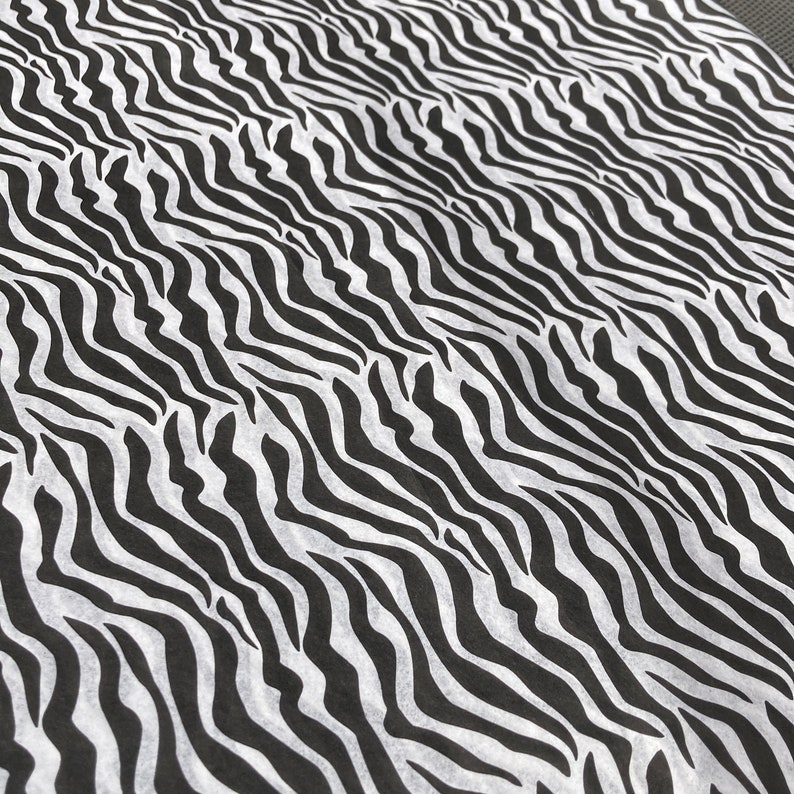 Puede incluir: Tela de estampado de cebra en blanco y negro con un patr&oacute;n ondulado.